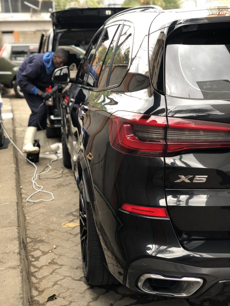 Gleaming black BMW X5 after a Full Detail while the team works on the next car